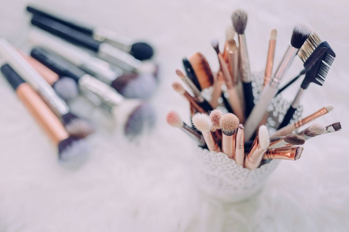 Side-by-side comparison of 5 makeup powder brushes showing shape, density, and fiber type labeled clearly