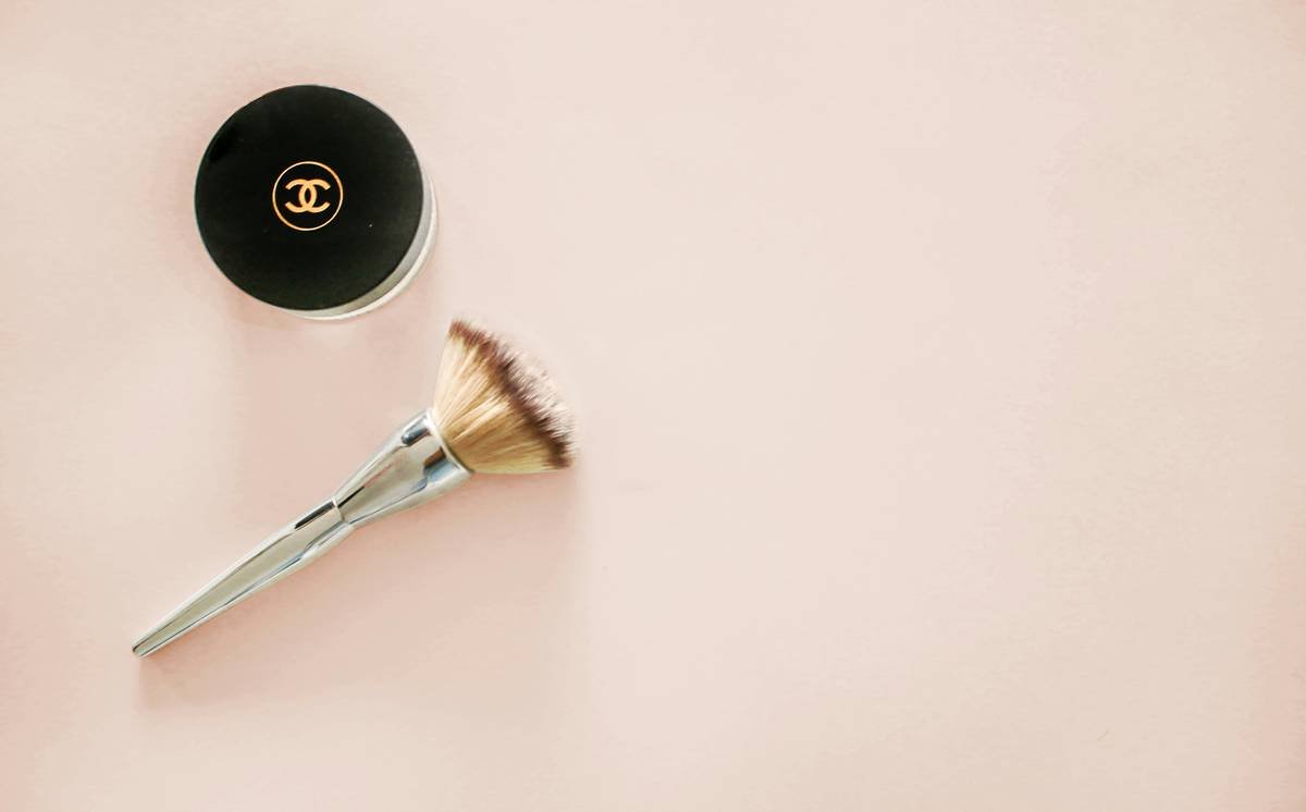 Infographic comparing flat-top, angled, and tapered foundation brushes showing bristle density, ideal formulas, and coverage levels