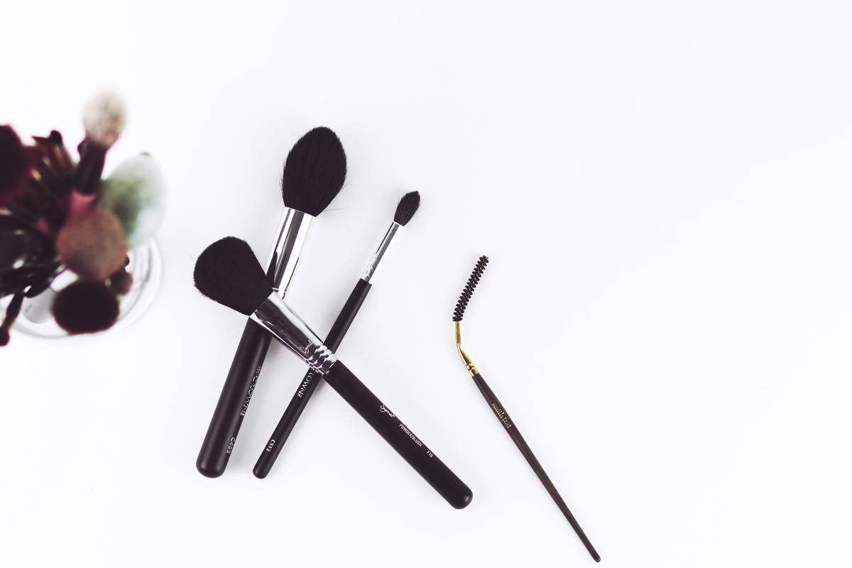 Side-by-side comparison of a true precision makeup brush (dense, tapered tip under 5mm) vs. a fake precision brush (splayed, wide bristles)