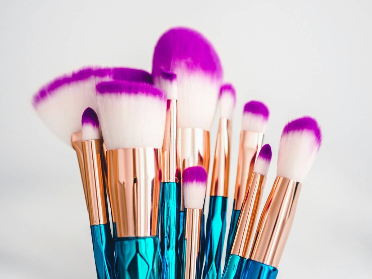 Infographic comparing low-quality vs high-quality makeup applicators showing bacterial growth, shedding fibers, and ergonomic differences