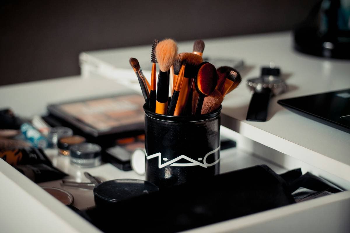 Infographic showing types of beauty applicator tools: synthetic brush for liquids, dense sponge for cream, fluffy brush for powder