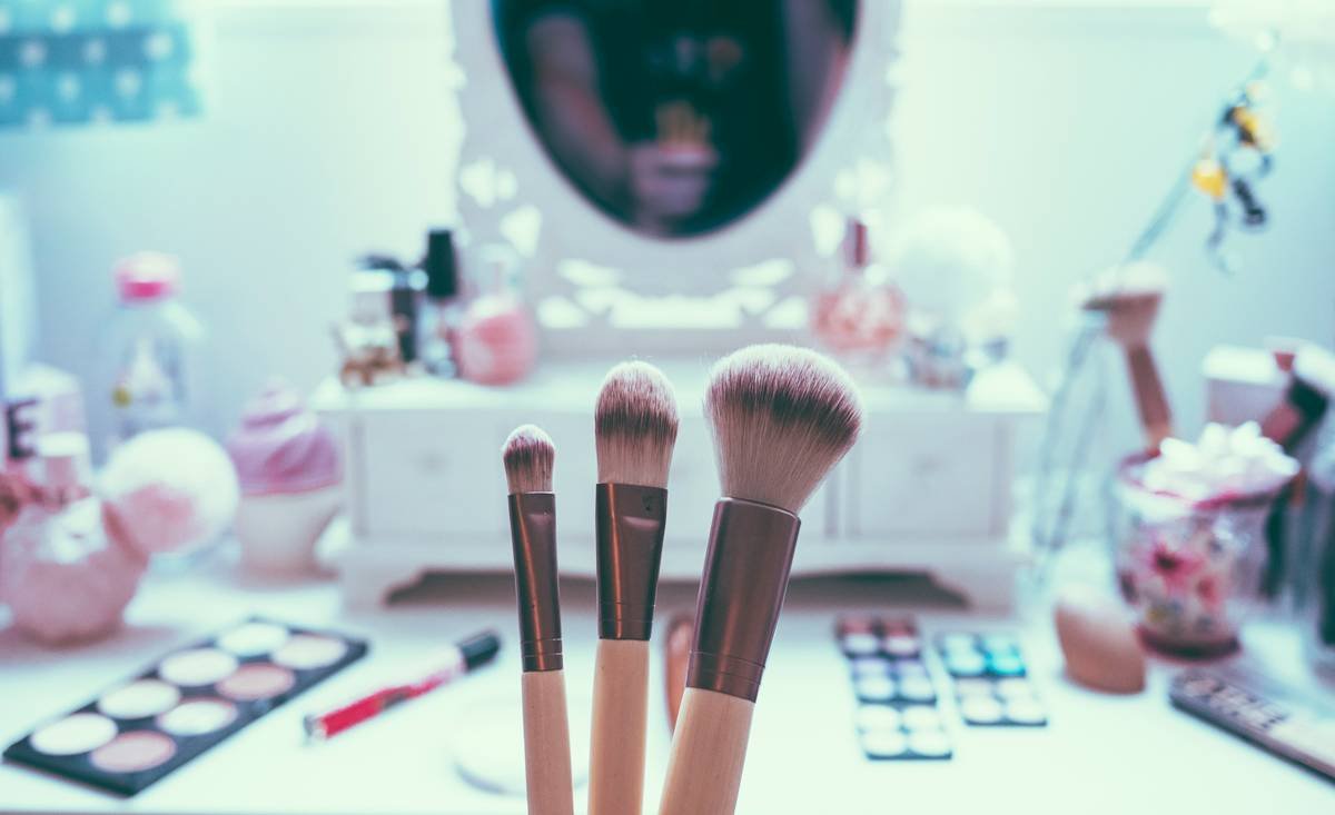 Close-up of high-quality cosmetic powder brush showing tapered bristles and balanced handle